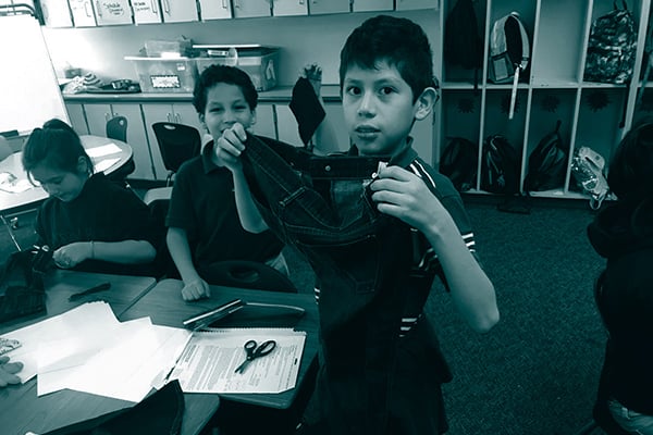 Elementary student holding jeans